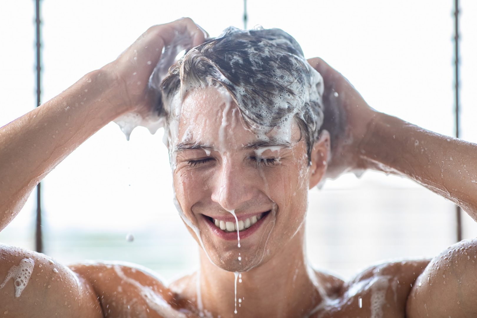 mannequin masculin se lavant les cheveux avec du shampoing